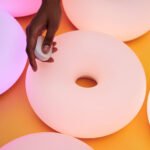 The new matte white VARMBLIXT donut lamp by Sabine Marcelis for IKEA, showcasing its diffused, smart lighting capabilities and elegant design.