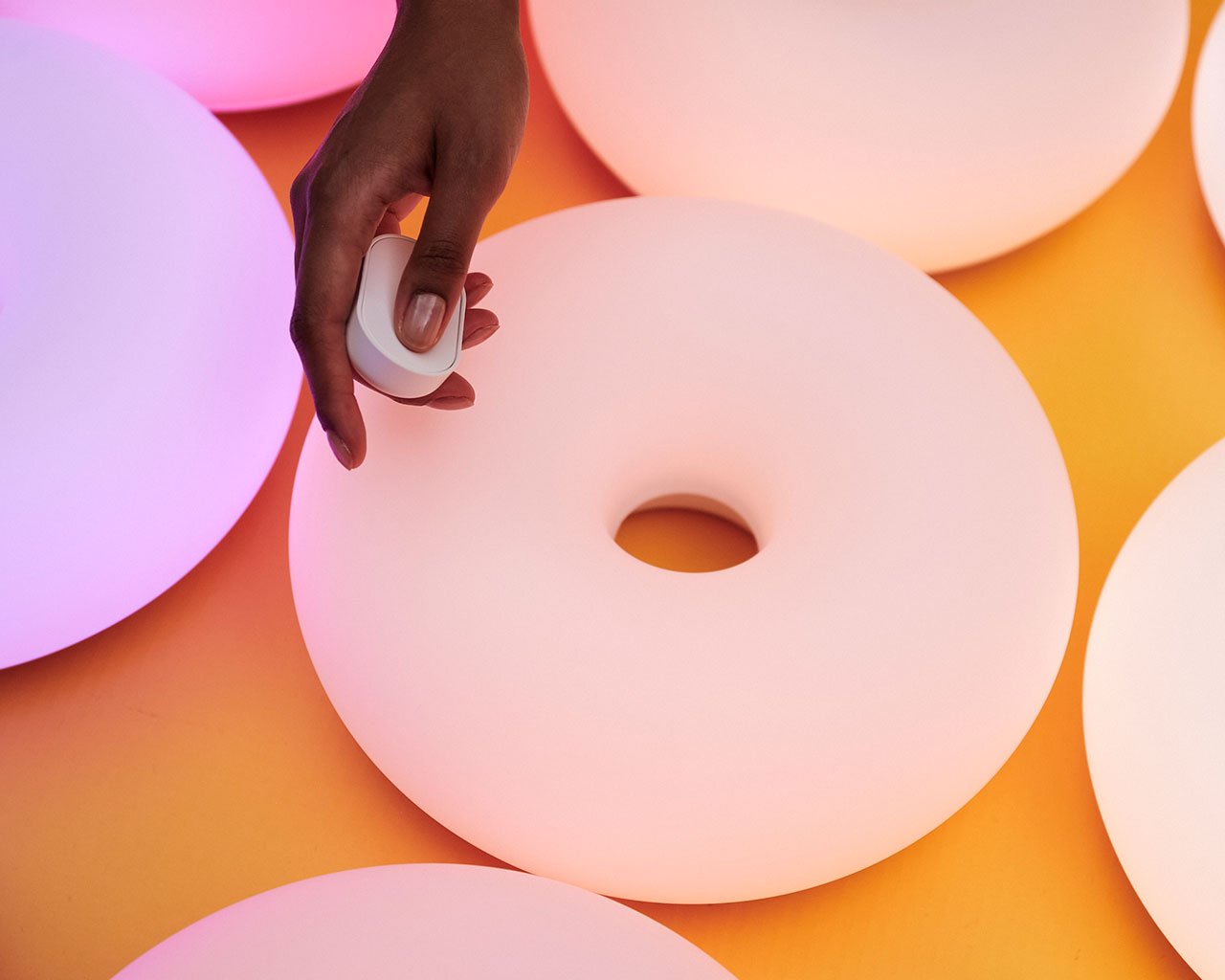 The new matte white VARMBLIXT donut lamp by Sabine Marcelis for IKEA, showcasing its diffused, smart lighting capabilities and elegant design.