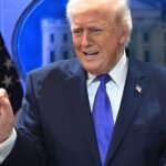 A politician speaking to a crowd, with economic charts or graphs in the background, symbolizing the disconnect between official data and public feeling.