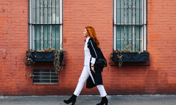 A person's feet in sneakers walking on a path, symbolizing the benefits of daily steps for heart health.