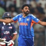 Cricket players in action during the T20 World Cup, with the stadium lights in the background.