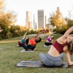 A person demonstrating Bow Pose (Dhanurasana) in yoga, stretching their back and hips.