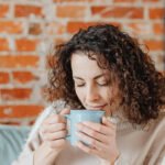 A steaming cup of coffee with various brain-boosting ingredients like cocoa powder and a supplement container nearby.