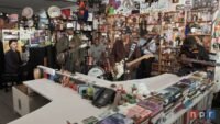 Buddy Guy and Miles Caton perform on stage with guitars at NPR's Tiny Desk Concert.