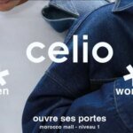 Une femme souriante portant des vêtements Celio Women, dans un décor moderne et lumineux, symbolisant le nouveau positionnement mixte de la marque.