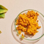A vibrant yellow spice, likely turmeric, in a bowl or on a spoon, symbolizing natural indigestion relief.
