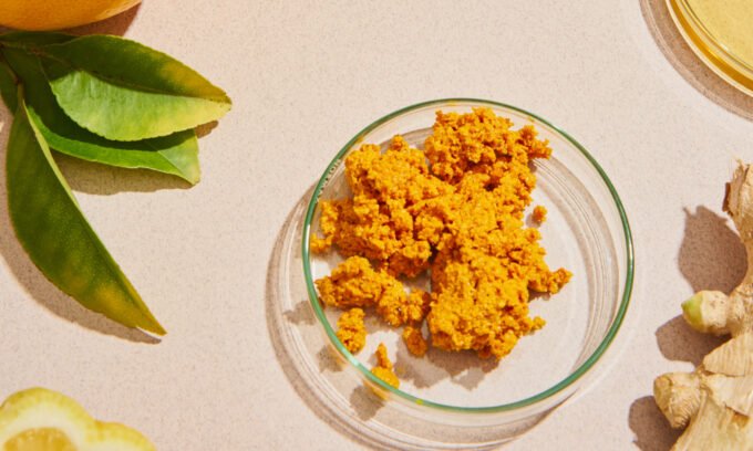 A vibrant yellow spice, likely turmeric, in a bowl or on a spoon, symbolizing natural indigestion relief.