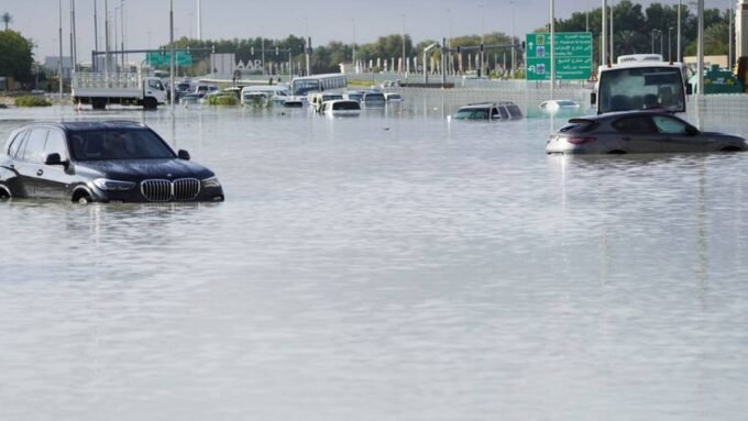 صورة تظهر سيارة تسير بصعوبة في طريق غمرته مياه الأمطار الغزيرة في الإمارات