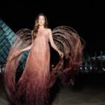 إيلين غو تتألق بفستان إيريس فان هيربن أمام هرم اللوفر في باريس، تجسيداً لآلهة النصر.