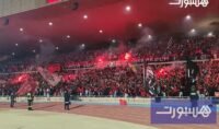 صورة بانورامية لمدرجات ملعب مراكش الكبير وهي تشتعل بحماس جماهير الكوكب المراكشي وأعلامهم الملونة وتيفوهاتهم الإبداعية.