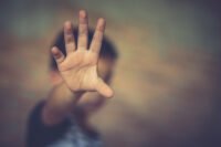 صورة توضيحية لأطفال يغادرون المدرسة مع إشارة إلى ضرورة الحذر من الغرباء.