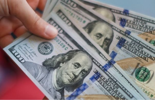 صورة تظهر عملة الدولار الأمريكي مع رسوم بيانية اقتصادية صاعدة، تعكس ارتفاع قيمته في الأسواق العالمية.