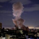 صورة جوية لمنشآت مدنية في منطقة الخليج تظهر عليها آثار هجوم أو طائرات مسيرة تحلق فوقها، تعكس التوترات الإقليمية.