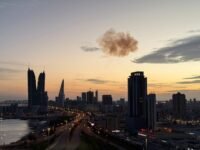 تصاعد الدخان بعد اعتراض طائرة إيرانية مسيرة فوق أبراج المنامة المالية، حيث تقع السفارة الإسرائيلية، في سياق الصراع الأمريكي الإسرائيلي مع إيران.