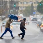 صورة تظهر أمطار غزيرة أو سيول في منطقة حضرية بالأردن مع سماء ملبدة بالغيوم.