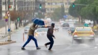 صورة تظهر أمطار غزيرة أو سيول في منطقة حضرية بالأردن مع سماء ملبدة بالغيوم.