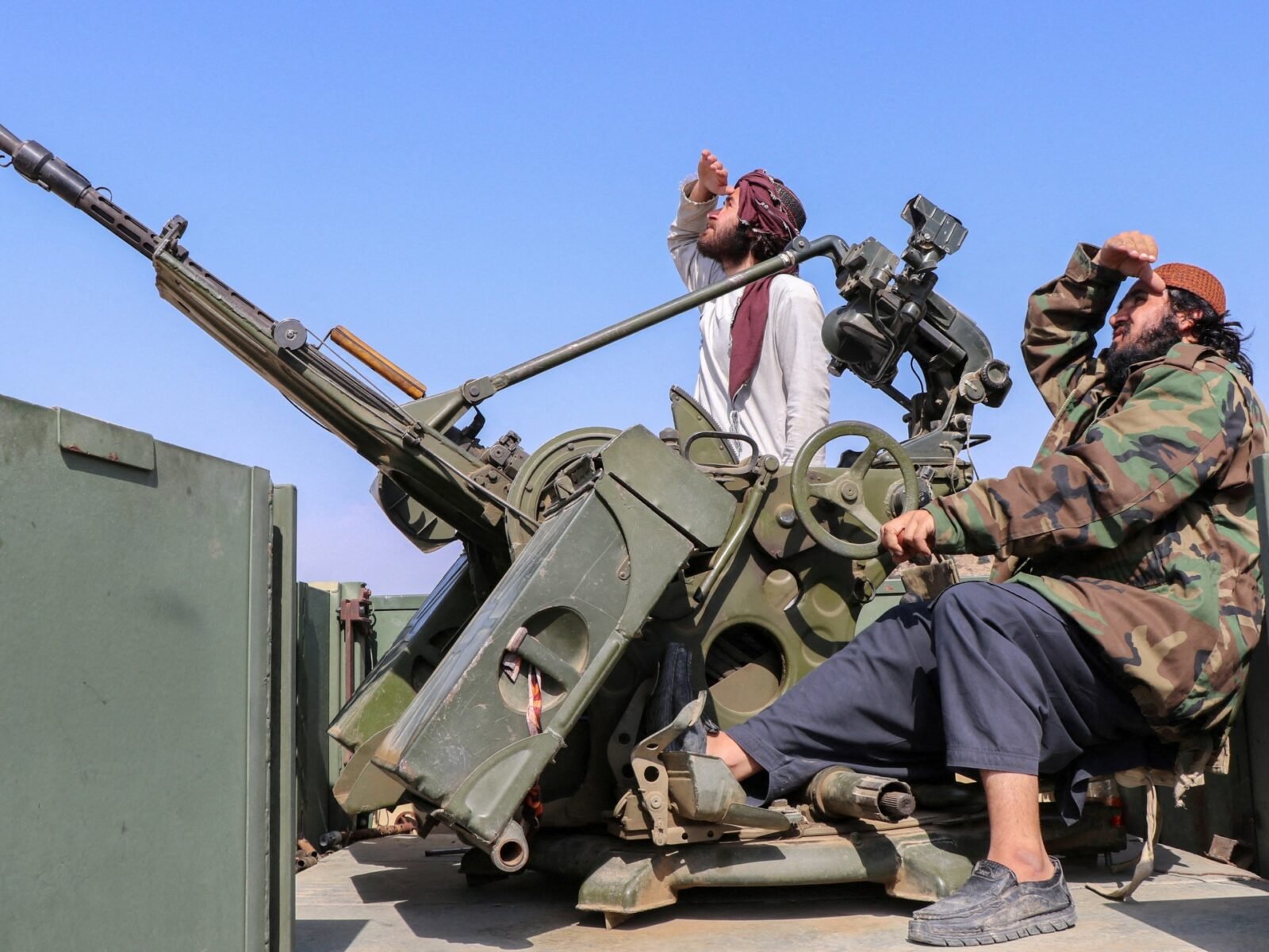 جنود من طالبان يراقبون الطائرات المقاتلة الباكستانية من موقع مضاد للطائرات في ولاية خوست، أفغانستان.