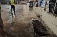 صورة لكوادر بلدية جرش وهي تعمل على معالجة تجمع مياه الأمطار في أحد شوارع المدينة.