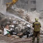 رجل إطفاء يخمد حطاماً متفحماً في مبنى سكني تعرض لهجوم أمريكي إسرائيلي في طهران، إيران، في 23 مارس 2026.