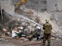 رجل إطفاء يخمد حطاماً متفحماً في مبنى سكني تعرض لهجوم أمريكي إسرائيلي في طهران، إيران، في 23 مارس 2026.