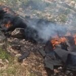 صورة لشظايا صاروخ أو حطام متساقط على الأرض، مع خلفية تظهر فرق الدفاع المدني أو الشرطة الأردنية.