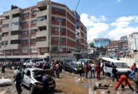 صورة لأشخاص يتفقدون سيارات محطمة جراء الفيضانات المفاجئة في منطقة جروجان، نيروبي، كينيا.