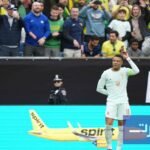 صورة جماعية للاعبي المنتخب الفرنسي يحتفلون بهدف خلال مباراة ودية ضد البرازيل، حيث يظهر كيليان مبابي وهو يشير إلى زملائه.