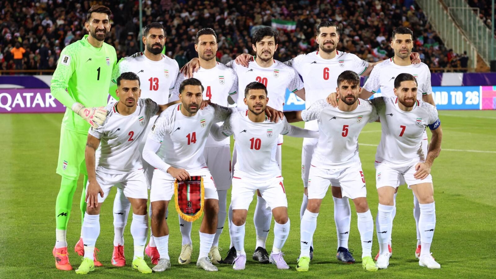 صورة توضيحية للمنتخب الإيراني وشعار كأس العالم 2026 في ظل توترات جيوسياسية.