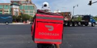 A DoorDash delivery driver filling up a car with gas, with the DoorDash logo visible.