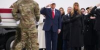President Donald Trump salutes as a flag-draped transfer case carrying the remains of a fallen U.S. soldier is moved at Dover Air Force Base.