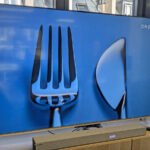 Le téléviseur Dreame 65Q100, un modèle QLED 4K élégant avec des bords fins et un pied doré, présenté de face.