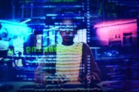 An entrepreneur thoughtfully crafting an AI prompt on a laptop, surrounded by visual representations of data and strategy.