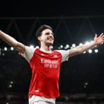 Arsenal and Manchester City players battling for possession on the pitch at Wembley Stadium during the EFL Cup final.