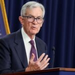 Federal Reserve Chair Jerome Powell speaking at a podium, discussing economic policy.