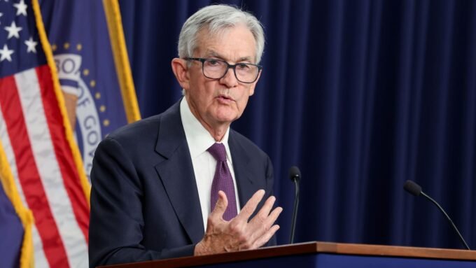 Federal Reserve Chair Jerome Powell speaking at a podium, discussing economic policy.