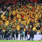 Le trophée de la CAN 2025, symbole de la victoire du Maroc après la décision de forfait du Sénégal, sur un fond de stade de football.