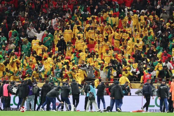 Le trophée de la CAN 2025, symbole de la victoire du Maroc après la décision de forfait du Sénégal, sur un fond de stade de football.
