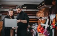 A person contemplating funeral arrangements, with a somber expression, symbolizing the emotional and financial weight of end-of-life planning.