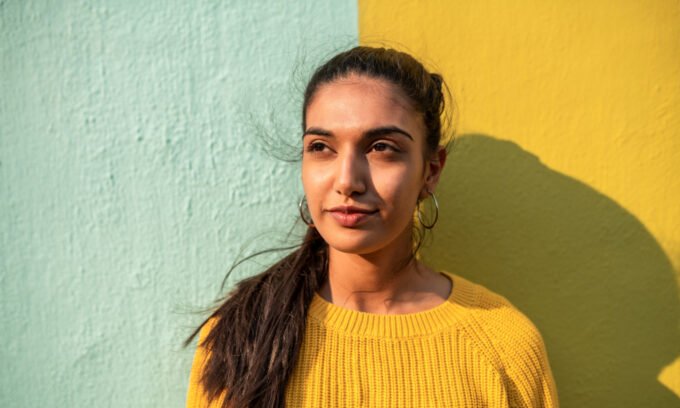 A person writing in a journal with a pen, surrounded by soft light, symbolizing reflection and gratitude.