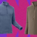 A person wearing a mid-layer jacket while hiking in a mountainous outdoor environment.