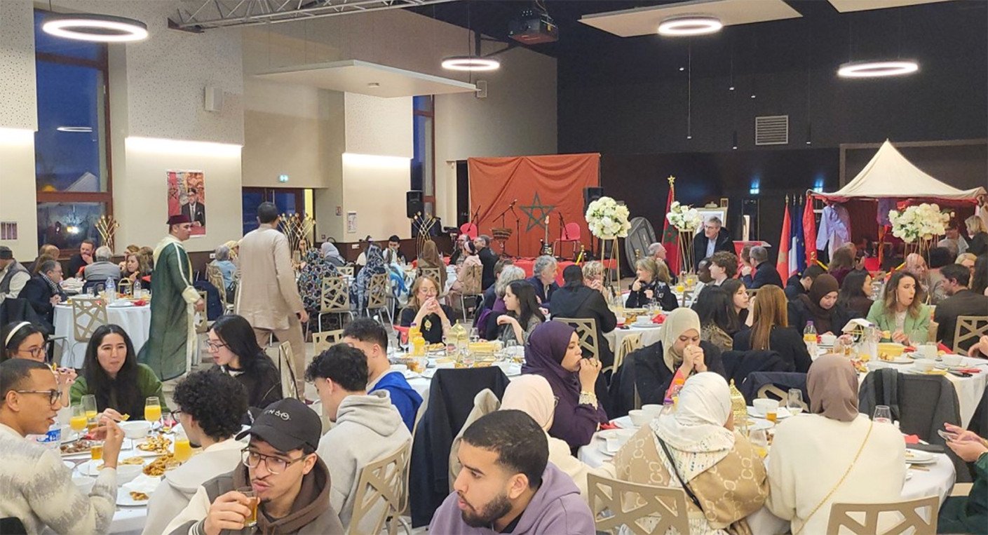 Représentants de cultes, élus et membres de la communauté marocaine partageant l'Iftar à Nancy, avec des musiciens en arrière-plan.