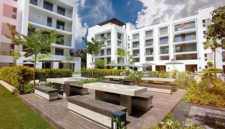 Graphique illustrant la hausse des prix immobiliers au Maroc en 2025, avec des flèches montantes et des silhouettes de bâtiments modernes et traditionnels.