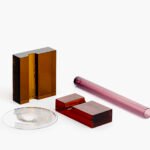 A composition from the Inchiostri exhibition, featuring layered colored glass blocks and tubes by Ronan Bouroullec and Giorgio Mastinu.