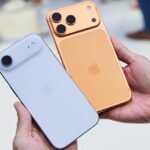 An iPhone 14 or later model pointing towards the sky, connecting to a satellite for location sharing in a remote landscape.