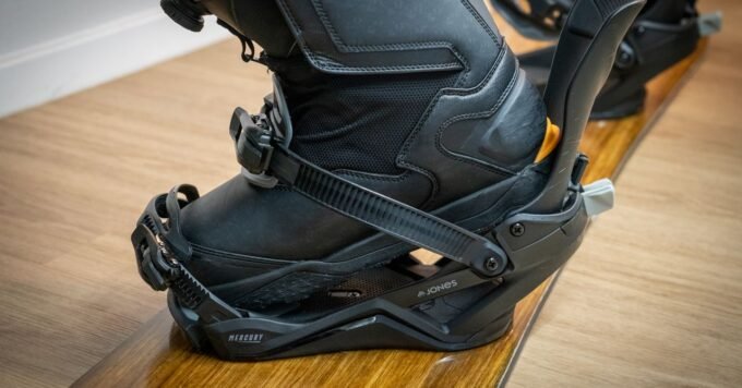 Jones Mercury FASE snowboard bindings mounted on a board in a snowy mountain landscape.