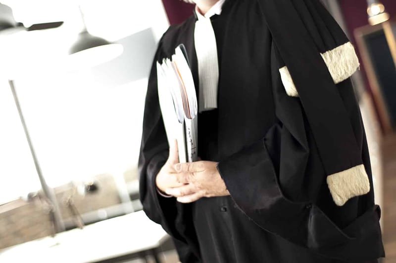 Justice en suspens : Le projet de loi des avocats, un silence assourdissant après la tempête 3 Une balance de justice stylisée, symbolisant l'équilibre et la profession d'avocat, avec un arrière-plan flou de documents juridiques et de mains en discussion, évoquant les tensions et les négociations autour du projet de loi.