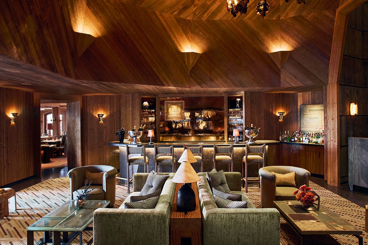 Interior view of L’Apogée Courchevel dining space, showcasing Kelly Wearstler's Alpine Brutalism design with textured wood and stone elements.