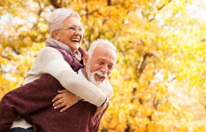 Un groupe de seniors souriants et actifs, utilisant des technologies modernes, symbolisant le dynamisme de la silver economy.