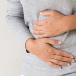 Une personne souriante et détendue après avoir mangé, symbolisant un ftour sans ballonnements.