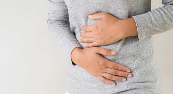 Une personne souriante et détendue après avoir mangé, symbolisant un ftour sans ballonnements.
